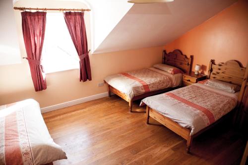 a bedroom with two beds and a window at Slieve League Lodge in Carrick