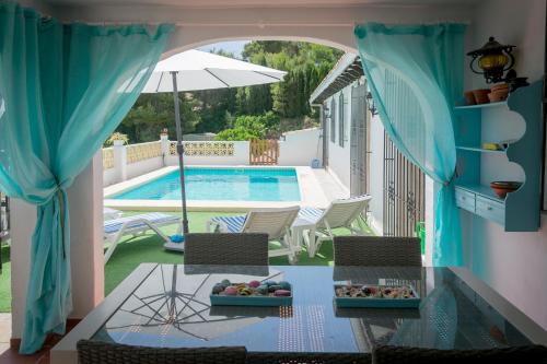 vistas a una piscina con mesa y sillas en Finca El León, en Benissa