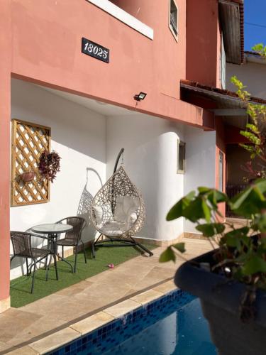 Casa lazer completo 200m da praia في برايا جراندي: فناء مع كراسي وطاولة بجانب مبنى