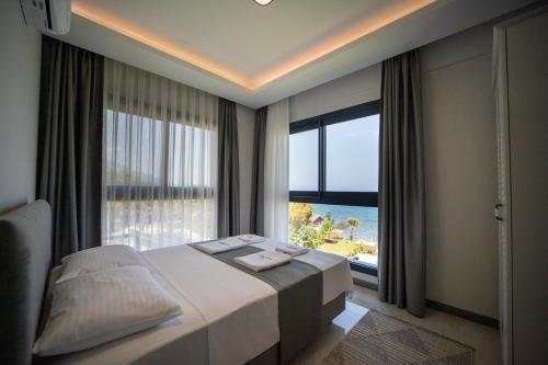 a bedroom with a bed and a large window at Artan Suites Tatil Evleri in Guzelcamlı