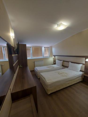 two beds in a hotel room with a staircase at Elegant Complex in Pazardzhik