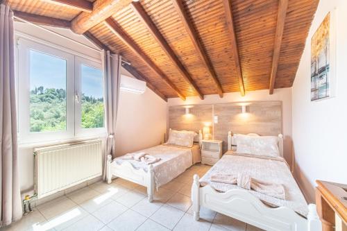 sypialnia z dwoma łóżkami i oknem w obiekcie Villa Logas w mieście Peroulades