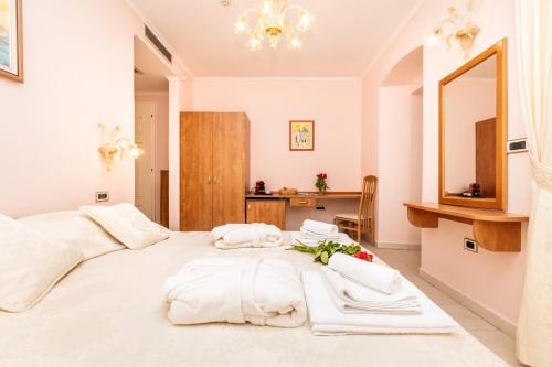 sypialnia z dużym białym łóżkiem z ręcznikami w obiekcie Villa Cassia w miejscowości Mali Lošinj