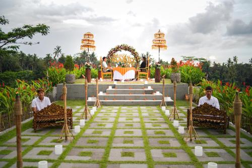 two men sitting in chairs in front of a temple at Kastara Resort in Ubud
