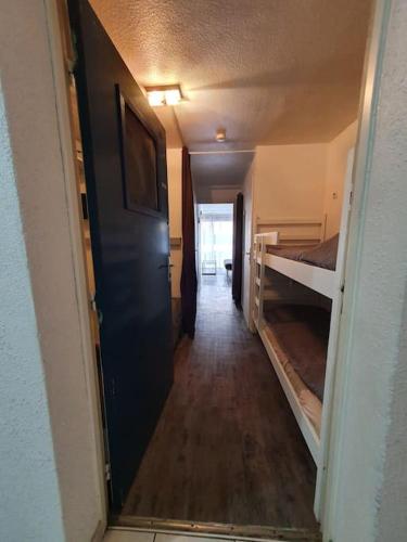 un couloir menant à une chambre avec des lits superposés dans l'établissement Le lagon bleu, au Grau-du-Roi