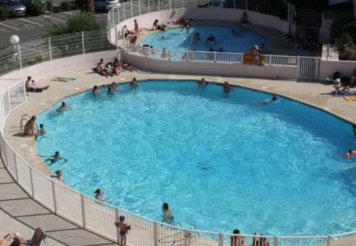 - une grande piscine avec des personnes dans l'établissement Le lagon bleu, au Grau-du-Roi