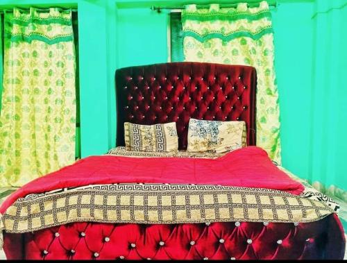 a red bed with a red head board and pillows at Kashmir premium hotel in Narul