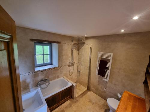 een badkamer met een bad, een wastafel en een toilet bij Gîte tout confort dans le Perche in Margon