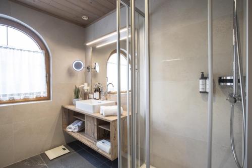 ein Bad mit einem Waschbecken und einer Dusche in der Unterkunft Romantik Ferienwohnungen in Pertisau
