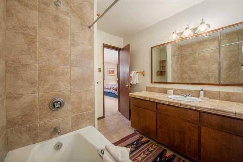 a bathroom with a tub and a sink and a mirror at Bray House - Ski-in Ski-out family home in Teton Village