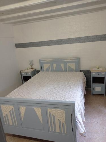 a bedroom with a white bed and two night stands at La maison du bonheur in Celavisa