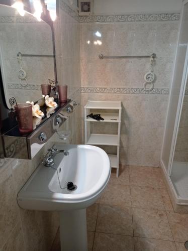 a bathroom with a white sink and a mirror at La maison du bonheur in Celavisa