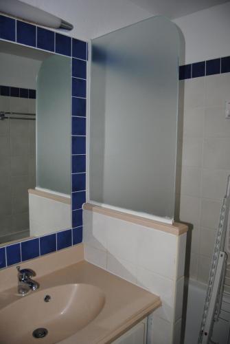 une salle de bain avec un lavabo et un miroir dans l'établissement T2 les pieds dans l'eau, mer et piscine, à Lacanau-Océan