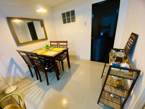Gillera Staycation in Lipa في ليبا: غرفة طعام مع طاولة وكراسي ومرآة