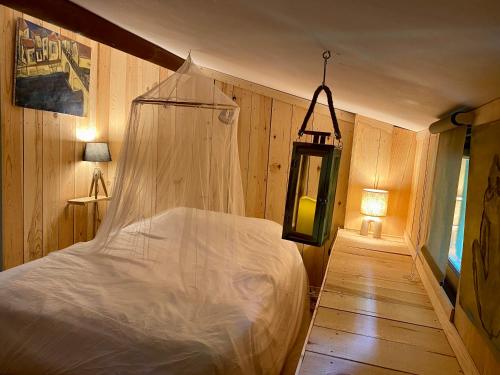 een slaapkamer met een bed met een klamboe bij Maison d'Hôtes - L'Hôthentique in Gaillan-en-Médoc