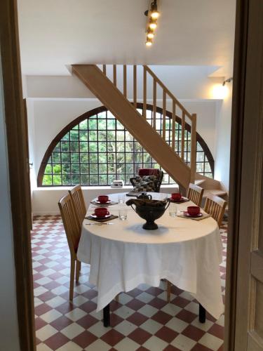 una sala da pranzo con tavolo e scala di Les chambres de Mont St Sébastien a Soignolles-en-Brie