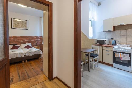 a room with a kitchen and a room with a bed at Apartamenty Kopernika in Toruń