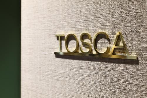a sign on the side of a building with the tasla logo at PRESTIGE BOUTIQUE APARTHOTEL - Piazza Duomo View in Milan
