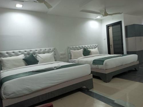 two beds sitting next to each other in a room at HOTEL BLUE MOON in Nellore