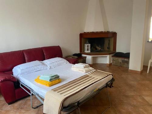 ein Bett im Wohnzimmer mit einem roten Sofa in der Unterkunft Casa Gina in Porto Torres