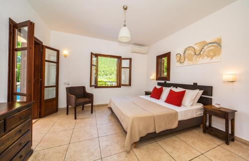Schlafzimmer mit einem Bett, einem Schreibtisch und einem Stuhl in der Unterkunft Rhodia Beach Villa in Stavros