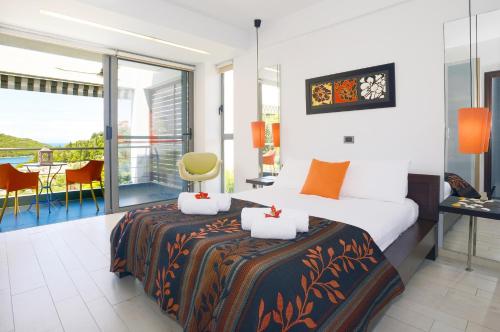 a hotel room with a bed and a balcony at Sivota Senses - Villa Loukas in Sivota