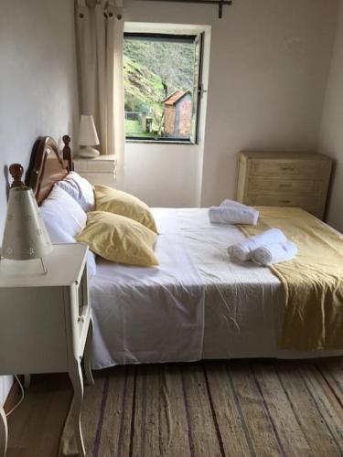 a bedroom with a large bed with a window at Casa do Moura in Arcos de Valdevez
