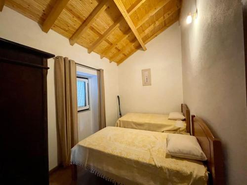 1 Schlafzimmer mit 2 Betten in einem Zimmer mit Fenster in der Unterkunft Casa do Moura in Arcos de Valdevez