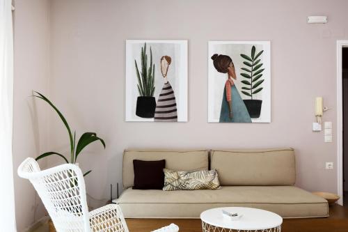 sala de estar con sofá y 3 pinturas en la pared en Sti Chora Apartments, en Lefkada