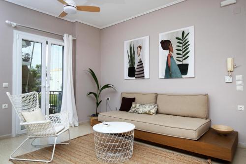 a living room with a couch and a table and chairs at Sti Chora Apartments in Lefkada Town
