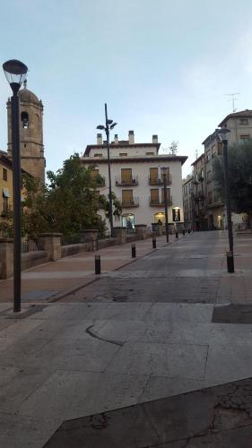 una calle vacía con un edificio y un semáforo en Apartamentos Alcañiz, Silvia en Alcañiz