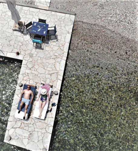 an aerial view of a man sitting on a patio at Symi . VILLA CALME (Sur la Mer). in Symi