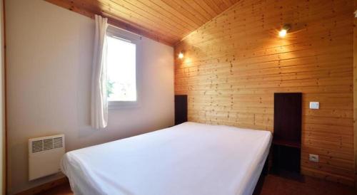 a bedroom with a white bed and a window at chez Sabine et Bertrand in Beynat
