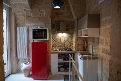 a kitchen with a red refrigerator in a room at Antica Cisterna di Lecce in Lecce
