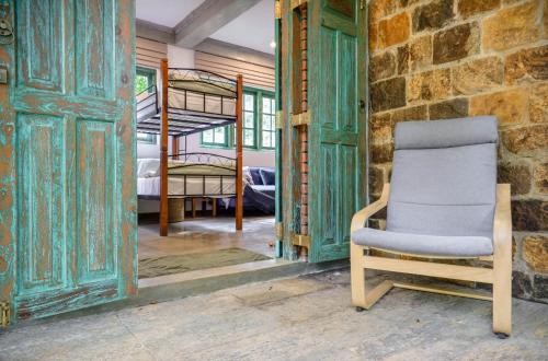 a chair in a room with two bunk beds at Tranquilisle in Kandy