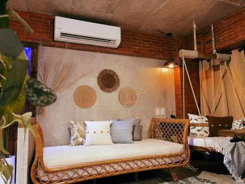 a wicker couch in a room with a air conditioner at CLOCKWORKORANGE Luxury Suites 4-Minutes Away To Airport in Mactan