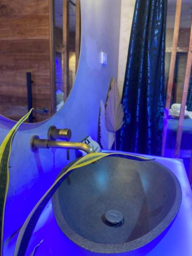 a blue bathroom with a sink and a mirror at CLOCKWORKORANGE Luxury Suites 4-Minutes Away To Airport in Mactan