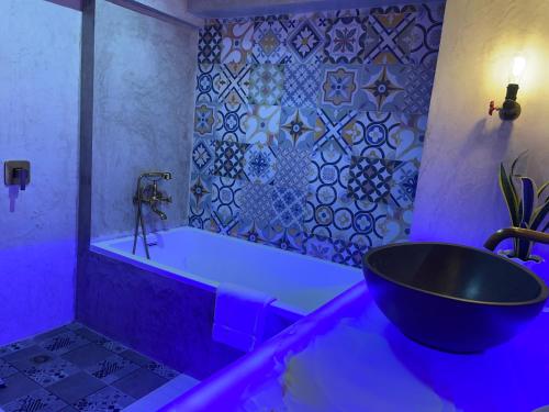 a bathroom with a tub and a black sink at CLOCKWORKORANGE Luxury Suites 4-Minutes Away To Airport in Mactan