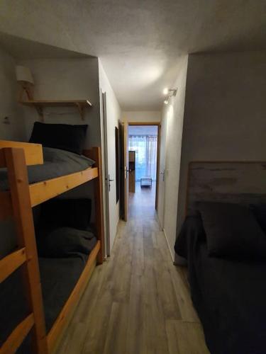 Cette chambre comprend 2 lits superposés et un couloir. dans l'établissement Le Lagon Bleu 4 Personnes, au Grau-du-Roi