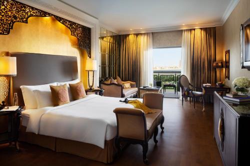 a bedroom with a large bed and a living room at Jumeirah Zabeel Saray Dubai in Dubai