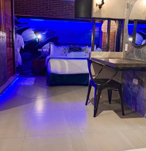 a room with a bed with a table and blue lights at CLOCKWORKORANGE Luxury Suites 4-Minutes Away To Airport in Mactan
