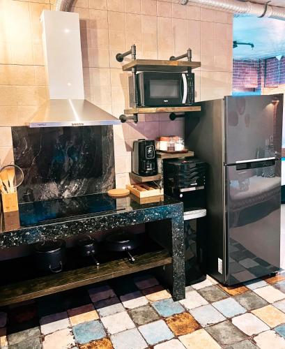 a kitchen with a stove and a refrigerator at CLOCKWORKORANGE Luxury Suites 4-Minutes Away To Airport in Mactan