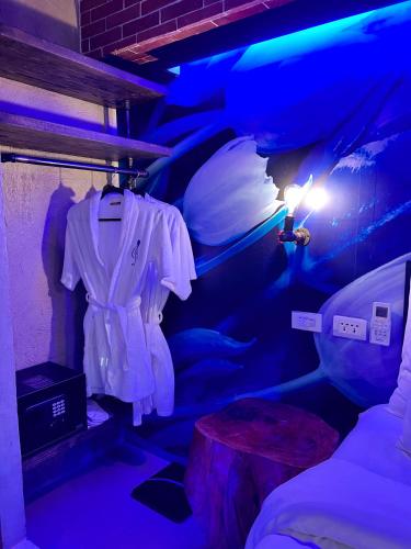 a room with a bed with a white shirt and a table at CLOCKWORKORANGE Luxury Suites 4-Minutes Away To Airport in Mactan
