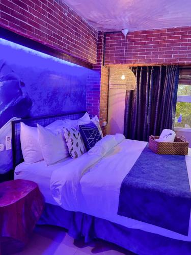 a bedroom with a large white bed and a brick wall at CLOCKWORKORANGE Luxury Suites 4-Minutes Away To Airport in Mactan