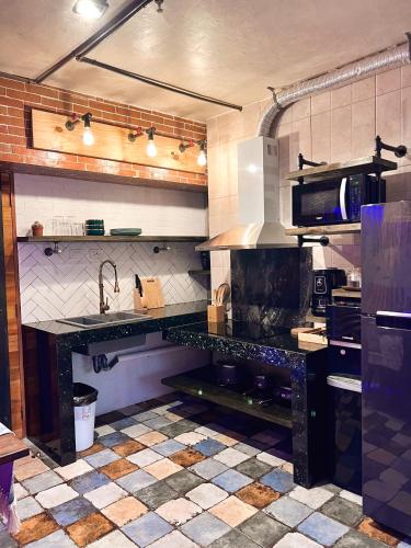 a kitchen with a black counter top in a room at CLOCKWORKORANGE Luxury Suites 4-Minutes Away To Airport in Mactan