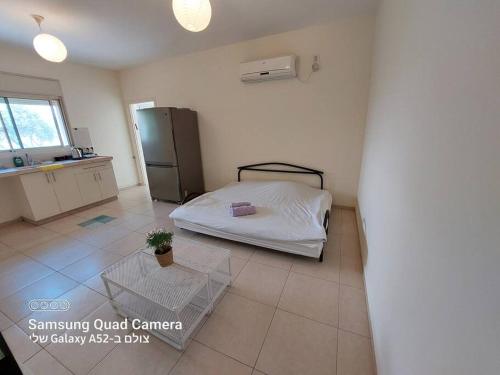 a small bedroom with a bed and a refrigerator at הממלכה הקסומה של מאיה ושלושת הפיות in Gonen