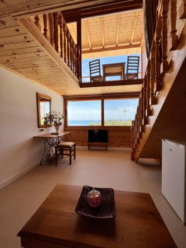 a living room with stairs and a table at Nashos Bungalows in (( Spile ))