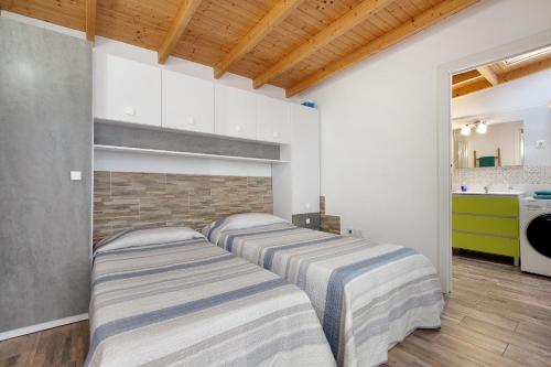 a row of beds in a room with a kitchen at Laikas house in Costa Calma
