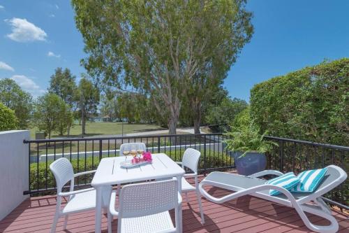 a patio with a white table and chairs on a deck at Villa Aqua 6 - Riverfront Noosaville in Noosaville