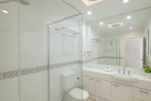 Villa Aqua 6 - Riverfront Noosaville في نوسافيل: حمام ابيض مع مرحاض ومغسلة